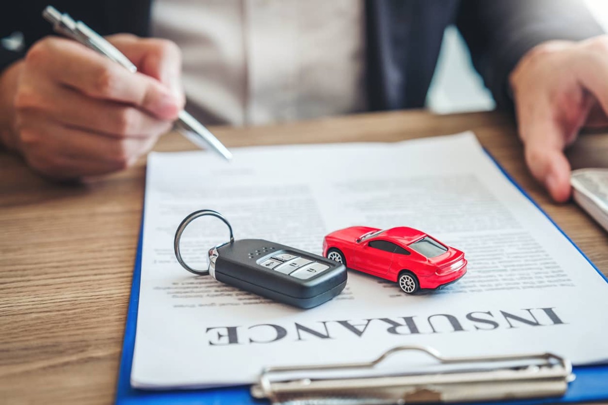 Car keys and paperwork on a desk while arranging car insurance